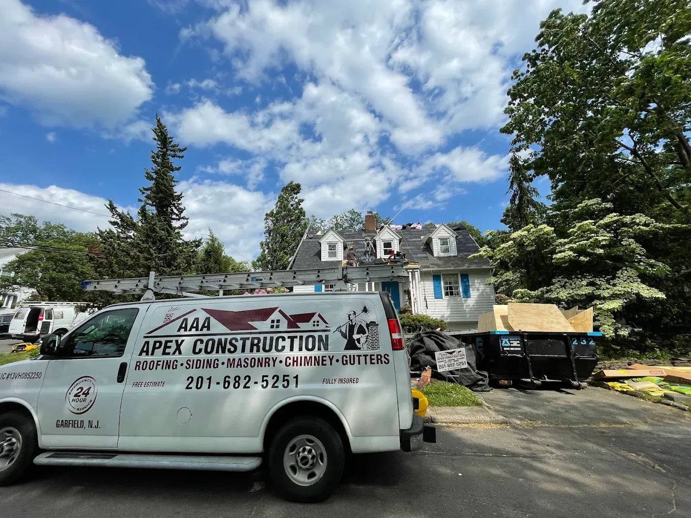 The AAA Apex van parked in front of a colonial house with dormers being re-roofed