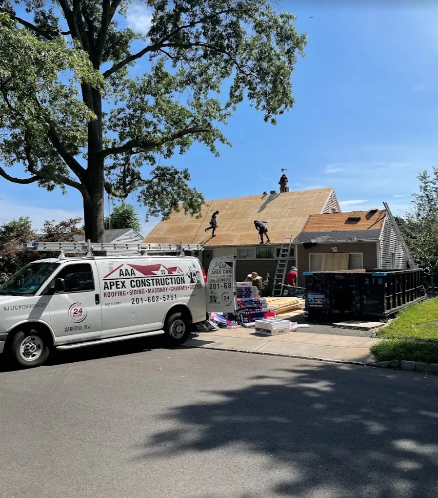 The AAA Apex van parked under a large oak tree while the crew re-roofs a ranch house
